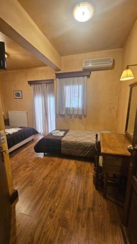 a bedroom with two beds and a desk and a piano at Villa Virginia Hotel in Karpenision
