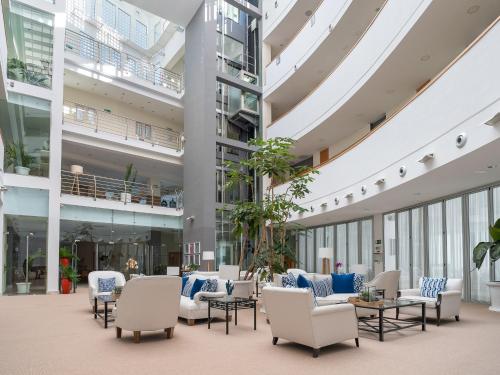 an empty lobby of a building with chairs and tables at Hotel Fuerte Conil-Resort in Conil de la Frontera
