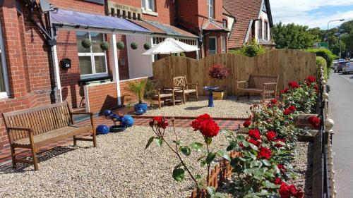 a backyard with benches and flowers and a fence at Launceston Villa in Whitby