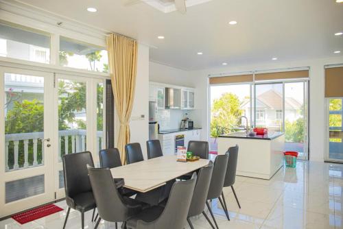 a kitchen and dining room with a table and chairs at Sun House -Villa Sealink Phan Thiết - Mũi Né in Phan Thiet