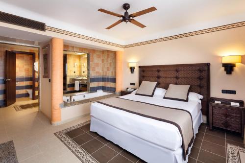 a bedroom with a large bed and a bath tub at Hotel Riu Touareg - All Inclusive in Curral Velho