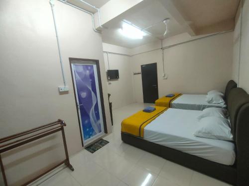 a room with two beds and a large window at RS INN in Rantau Panjang