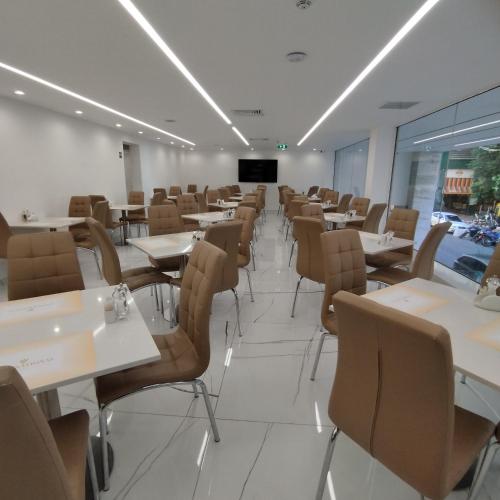 a dining room with tables and chairs and a screen at International Atene hotel in Athens