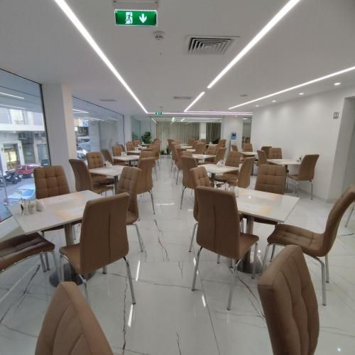 a dining room with tables and chairs and a clock at International Atene hotel in Athens