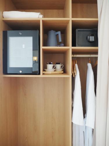 a tv and a microwave in a closet at Logis Hôtel de Carantec in Carantec