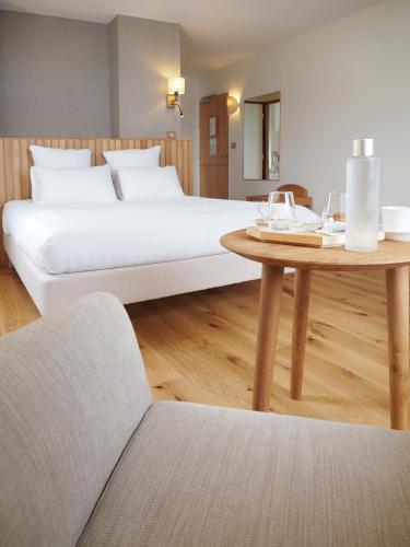 a bedroom with a large bed and a table at Logis Hôtel de Carantec in Carantec