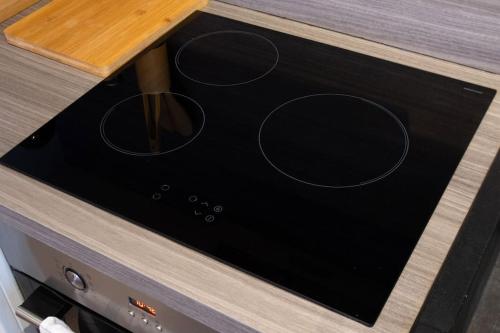 a microwave oven with four dials on a counter at Au cœur des vignes Proche Disneyland in Crézancy