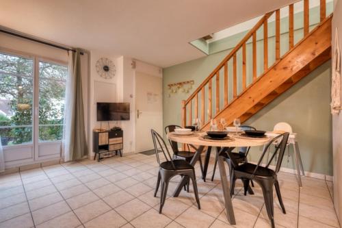une salle à manger avec une table et des chaises et un escalier dans l'établissement Ma maison à Disneyland Paris, à Magny-le-Hongre