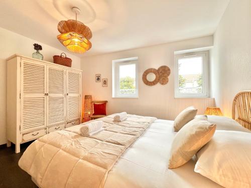 une chambre avec un grand lit blanc et deux fenêtres dans l'établissement Le Bobochic - Calme & Élégance au Cœur de la Ville, à Mont-de-Marsan