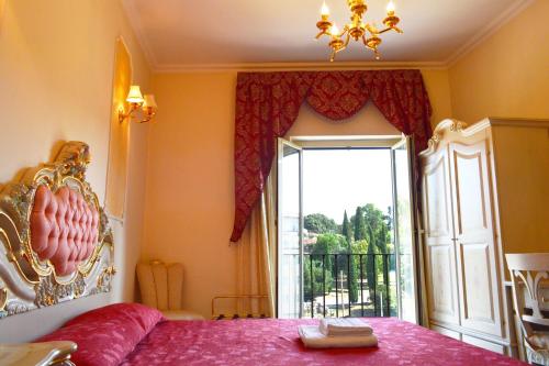 sypialnia z różowym łóżkiem i dużym oknem w obiekcie Colosseo Rooms Imperial Rome w Rzymie