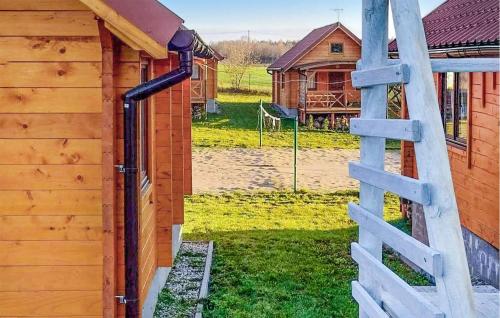 a wooden building with a ladder next to a yard at Gorgeous Home In Rybical With Kitchen in Ryn
