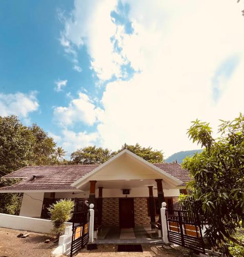 a house with a fence in front of it at Green and Green in Vagamon