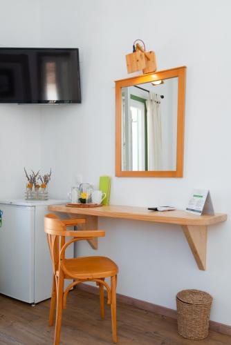 a mirror on a wall with a table and a chair at Margado in Kamarai