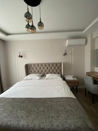 a bedroom with a large white bed and a desk at ANTİGONİA BUTİK OTEL in İznik
