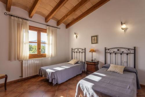 een slaapkamer met twee bedden en een raam bij Villa Cas Mestre in Selva