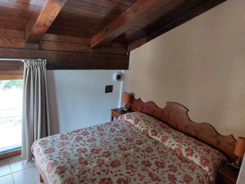 sypialnia z łóżkiem w pokoju z drewnianym sufitem w obiekcie Residence Les Lacs w mieście Bardonecchia