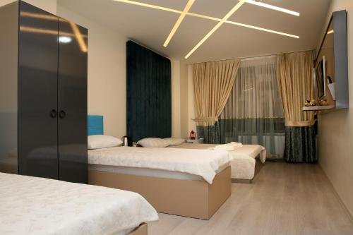 een hotelkamer met drie bedden en een televisie bij Blueway Hotel Istanbul Bakırköy City Center in Istanbul