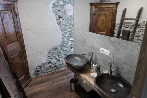 a bathroom with a sink and a stone wall at Casa Sofia in Aosta