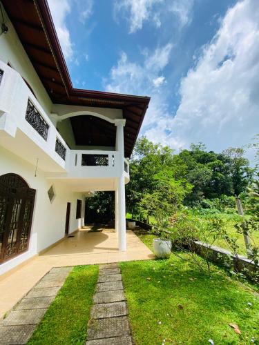 an external view of a house with a grass yard at Havindu Nethmika in Horangalla
