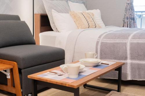 a living room with a bed and a coffee table at shinjuku lions house newly renovated, elevator, washmachine,kitchen in Tokyo
