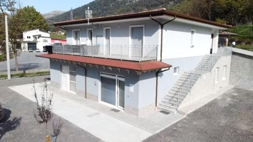 a white house with stairs on the side of it at Moon Valley Holiday Home in Lauria