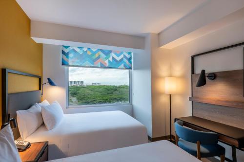 a hotel room with two beds and a window at Tru By Hilton Cali Sur in Cali