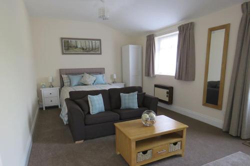 a living room with a couch and a bed at The Stables at Nyland View, Cheddar in Cheddar