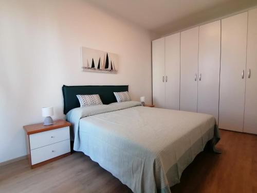 a bedroom with a large bed and white cabinets at Appartamento Delfino Blu in Porto Torres