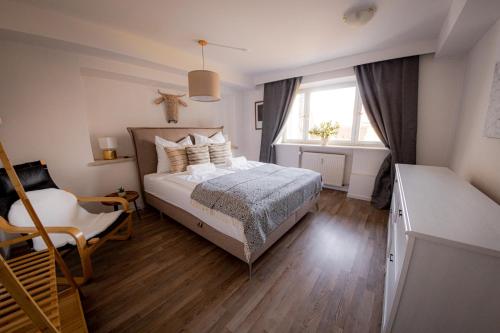 a bedroom with a bed and a window at Yello Homes - Gemütliche und luxuriöse Wohnung - mit Sauna, Garten, und Heimkino für 6 Personen in Anger