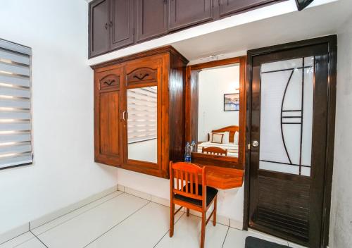 a room with a wooden desk and a bedroom at Pop Tavern Kovalam Beach Villa by VOYE HOMES in Kovalam