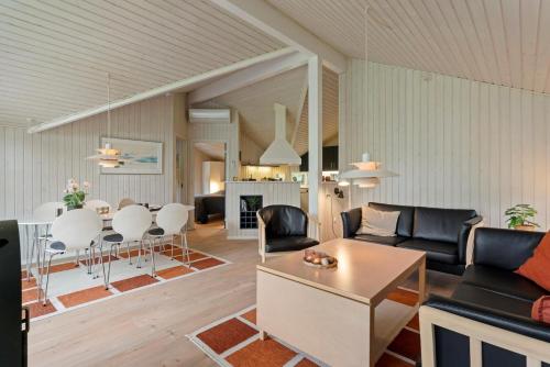 a living room with a couch and a table at Summer House Close To Nature And Beach in Dronningmølle
