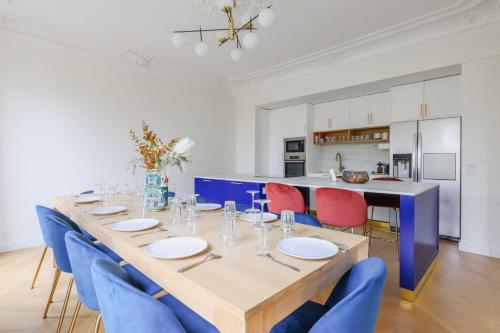 une salle à manger avec une grande table et des chaises bleues dans l'établissement Luxurious apartment - 4BR-10P- Ternes-Pereire, à Paris
