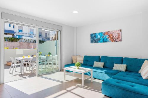 a living room with a blue couch and a table at MEDANO4YOU Lego House in El Médano