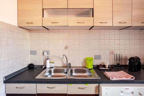 a kitchen with a stainless steel sink and cabinets at A Home away From Home By Alex in Busto Arsizio