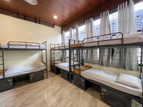 a room with three bunk beds in it at Ananya Dorms in Hospet