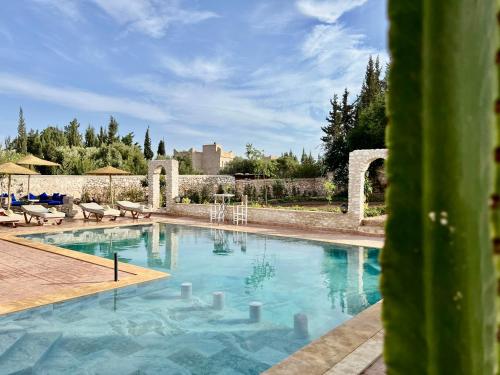 a large swimming pool with blue water in a yard at Villa Serinie in Essaouira