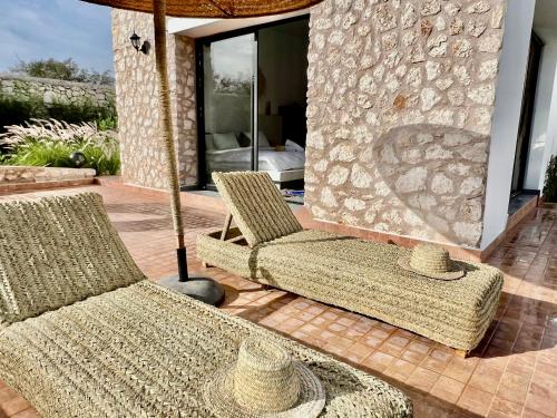 two chairs and an umbrella on a patio at Villa Serinie in Essaouira