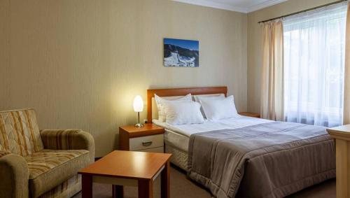 a hotel room with a bed and a chair at Bukovel Hotel in Bukovel
