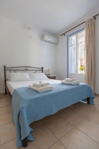 a bedroom with a bed with two towels on it at Astarti Apartments in Livadi