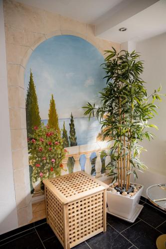a bathroom with a wall with a painting and plants at Yello Homes - Gemütliche und luxuriöse Wohnung - mit Sauna, Garten, und Heimkino für 6 Personen in Anger