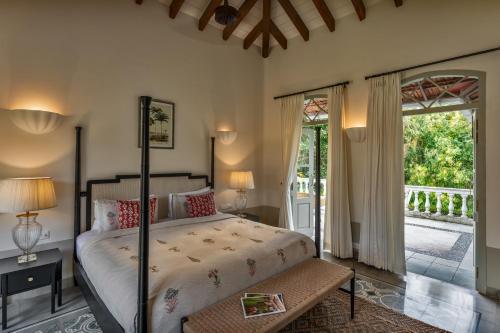 a bedroom with a bed and a large window at La Rozalia, Exquisite 4 BHK Villas with Large Pool, Garden, Dedicated Caretaker, Terrace, 2 mins from the famous Dear Zindagi Road in Mapusa