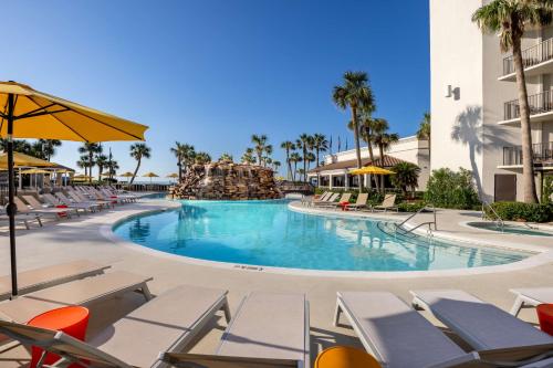 a pool at the resort with chairs and a water slide at Hilton Galveston Island Resort in Galveston