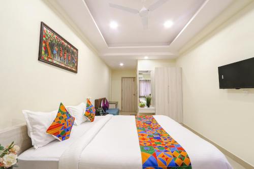 a bedroom with a large bed and a flat screen tv at FabHotel Metro - Nr Secunderabad Railway Station in Hyderabad
