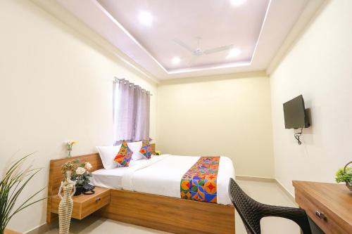a bedroom with a bed and a desk and a tv at FabHotel Metro - Nr Secunderabad Railway Station in Hyderabad