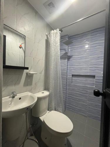 a bathroom with a toilet and a sink and a shower at Lisro Sleep and Relax in San Juan