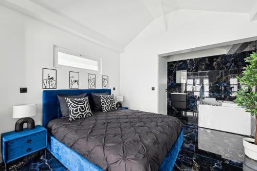 a bedroom with a blue bed and a bathroom at Suite prestige avec jacuzzi in Pontault-Combault