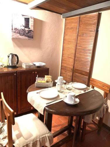 a dining room with a table and two chairs and a table and chairs at PienzaLettings Studio & Room in Pienza