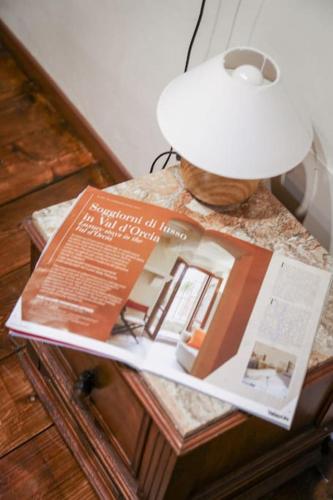 a magazine sitting on top of a table with a lamp at PienzaLettings Studio & Room in Pienza