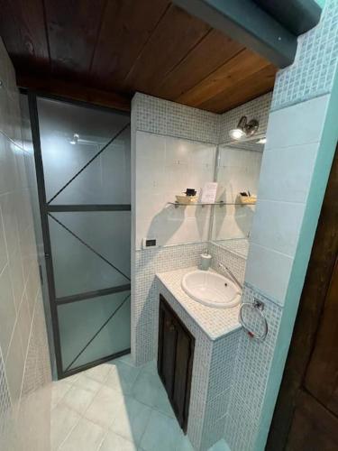 a bathroom with a sink and a glass wall at PienzaLettings Studio & Room in Pienza