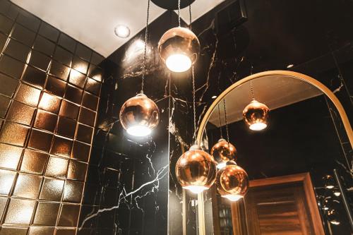 a group of lights hanging in a room with a mirror at Muzyczna Oaza Przy Rynku in Wrocław